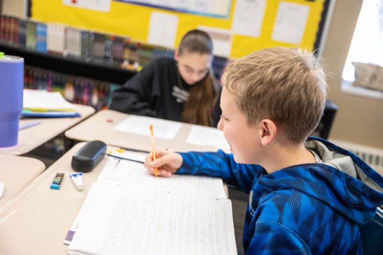 Student writing at his desk doing class work at Salem Lutheran school in Greenfield, MN
