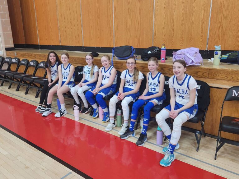 Girls basketball team at Salem Lutheran School in Greenfield, MN sitting on the bench preparing for the game