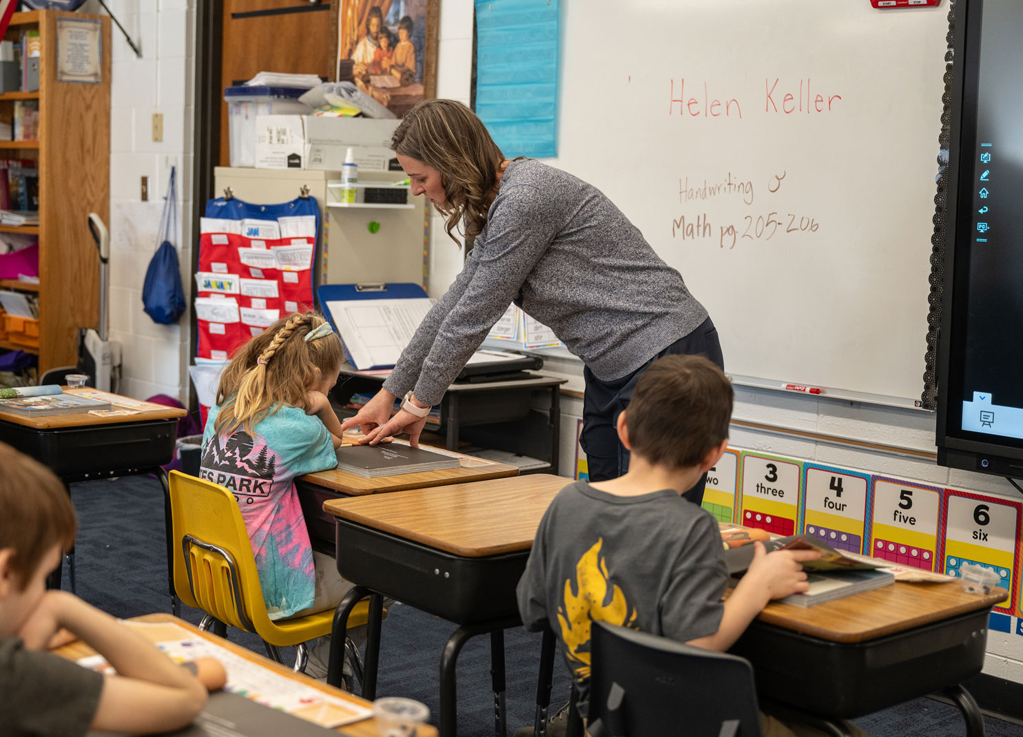 Teacher helping students with their school work at Salem Lutheran School, Math